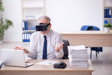 Old businessman employee wearing virtual glasses in the office