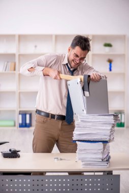 Young employee and too much work at workplace