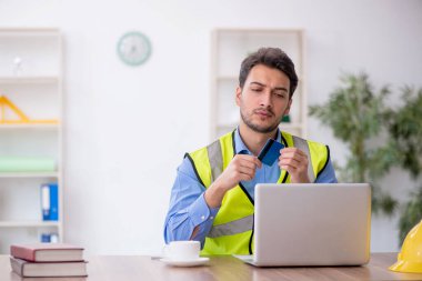 Genç mimar kredi kartı tutuyor.