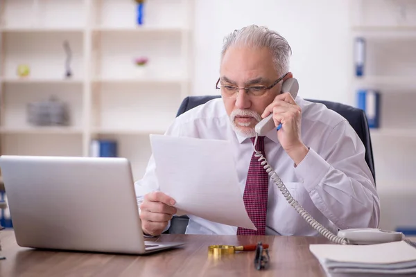 Stock image Old businessman employee and too much work in the office