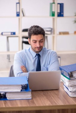 Young employee and too much work at workplace