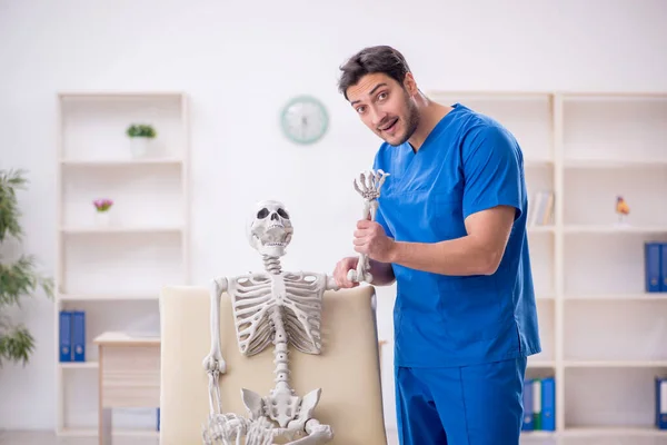 Νεαρός Άνδρας Γιατρός Και Σκελετός Ασθενής Στην Κλινική — Φωτογραφία Αρχείου