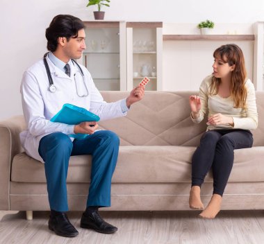 Genç, yakışıklı doktor, kadın hastayı evinde ziyaret ediyor.