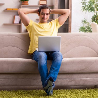 Genç erkek tele-çalışma konseptinde serbest çalışıyor.