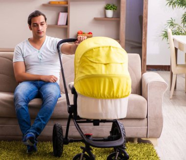 Genç müteahhit evde yeni doğan çocuğa bakıyor.