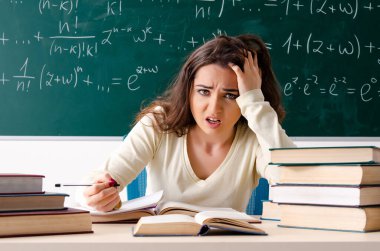 Tahtanın önündeki genç bayan matematik öğretmeni.