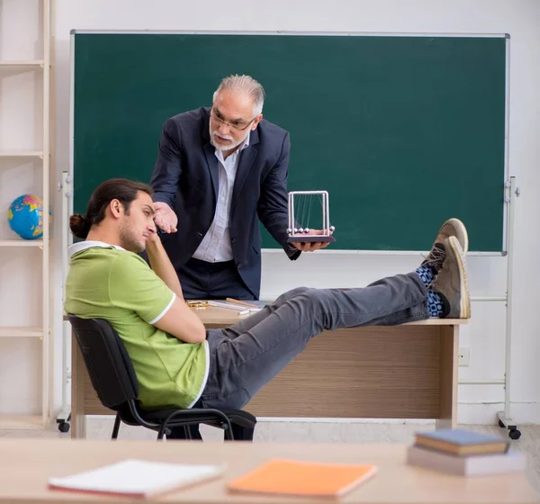 教室で高齢の物理の先生と若い学生 — ストック写真