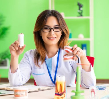 Diş implantı üzerinde çalışan dişçi kadın.