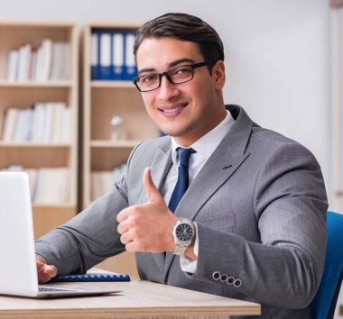 Masada oturan genç işadamı.