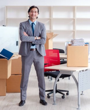 Ofiste kutuları olan genç adam.