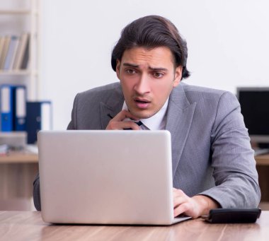 Genç erkek çalışan aşırı işten memnun değil.