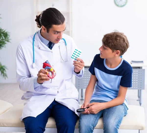 Den Unga Manliga Läkaren Undersöker Pojken Kliniken — Stockfoto