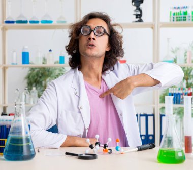 Laboratuvarda çalışan komik erkek kimyager.