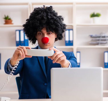 Ofiste çalışan genç palyaço işadamı.