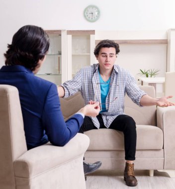 Genç erkek hasta psikologla kişisel sorunları tartışıyor.