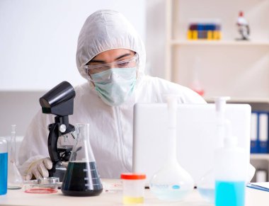 Laboratuvarda çalışan genç yakışıklı kimyager.