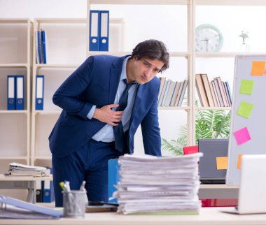 Genç erkek çalışan aşırı işten memnun değil.