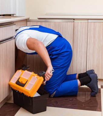 Mutfakta çalışan genç tamirci.