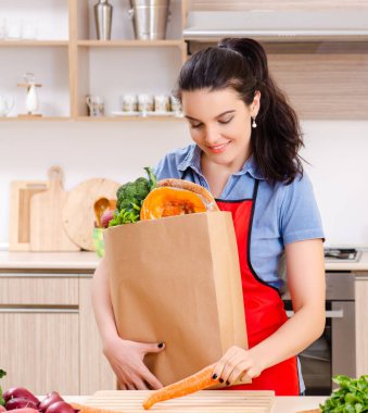 Mutfakta sebzeli genç kadın.