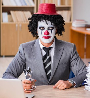 Ofiste çalışan palyaço işadamı.