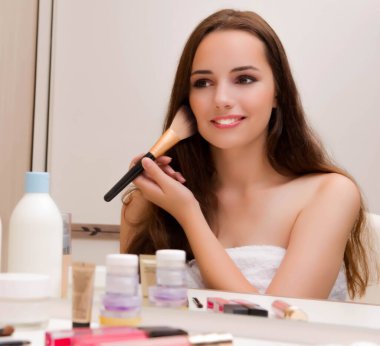 Evde makyaj yapan kadın partiye hazırlanıyor.