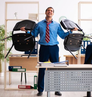 Genç işadamı iş yerinde spor egzersizleri yapıyor.