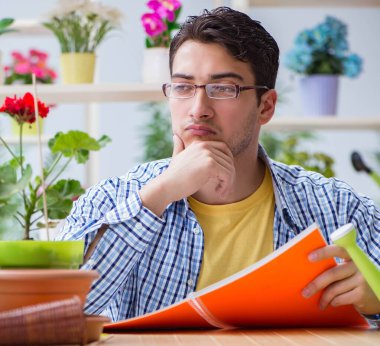 Çiçekçide çalışan genç adam.