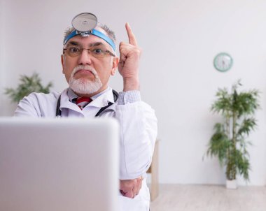 Klinikte çalışan yaşlı erkek doktor otolog.