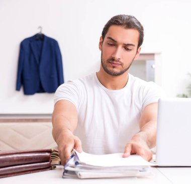 Genç erkek öğrenci evde sınavlara hazırlanıyor.