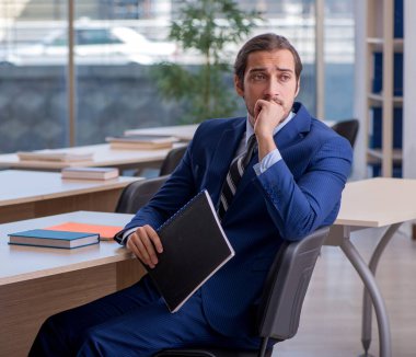 Sınıfta takım elbiseli bir öğretmen var.