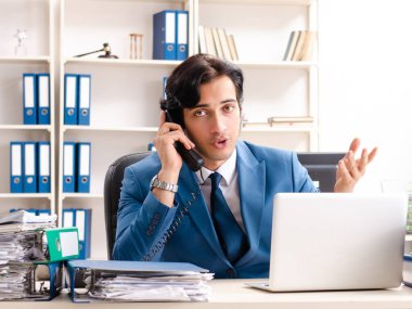 Genç, yakışıklı, meşgul çalışan ofiste oturuyor.