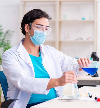 Laboratuvarda çalışan genç erkek kimyager.