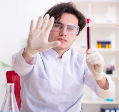 Laboratuvarda çalışan genç erkek biyokimyacı.
