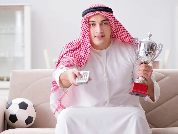 若いアラブ人の男はソファに座ってサッカーを見て — ストック写真