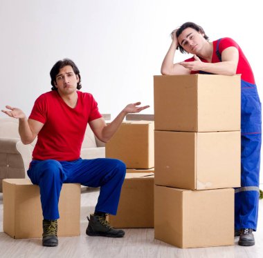 İki genç müteahhit kişisel eşyalarını taşıyor.