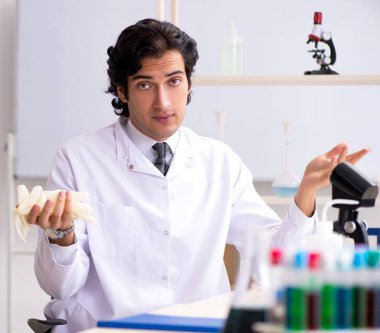 Laboratuvarda çalışan genç yakışıklı kimyager.