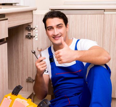 Mutfakta çalışan genç tamirci.