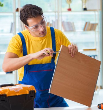 Mobilya marangozu atölyede çalışıyor.