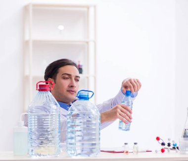 Laboratuvarda deney yapan genç erkek kimyager.