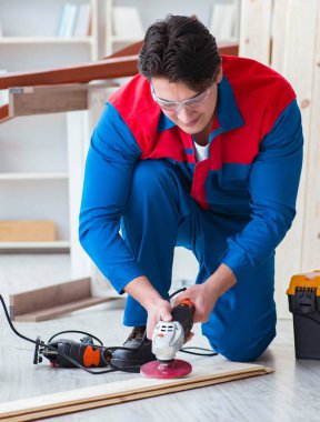 Genç marangoz ahşap kalaslarla çalışıyor.