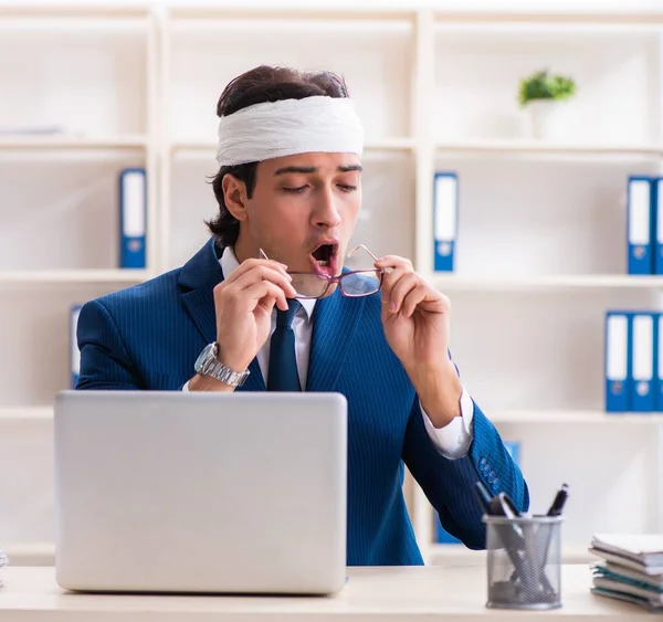 The head injured male employee working in the office