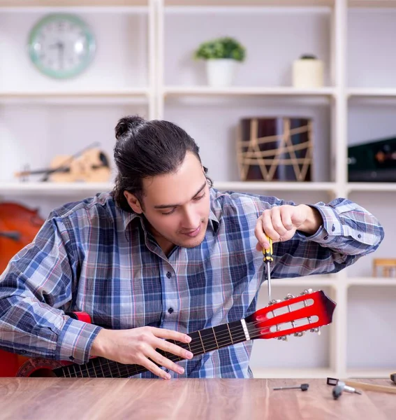 Der Junge Gutaussehende Reparateur Repariert Gitarre — Stockfoto