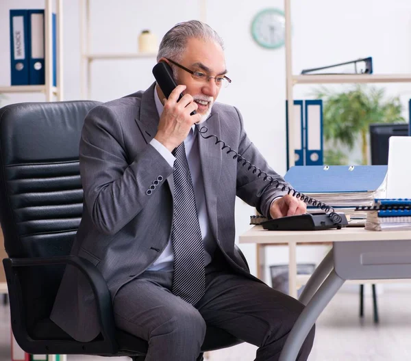 Ανώτερος Υπάλληλος Που Χρησιμοποιεί Τηλέφωνο Στο Γραφείο — Φωτογραφία Αρχείου