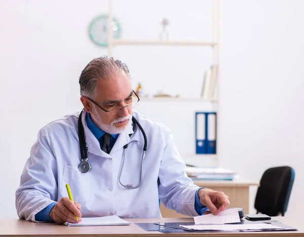Starszy Lekarz Kardiolog Patrząc Elektrokardiogram — Zdjęcie stockowe