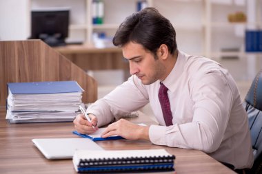 Genç işadamı ve işyerinde çok fazla iş var.