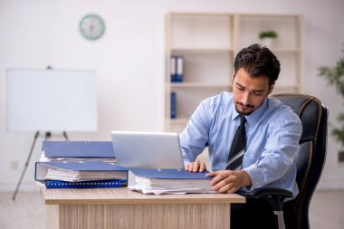 Genç işadamı işyerinde oturuyor.