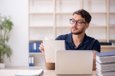 Genç çalışan işyerinde oturuyor.