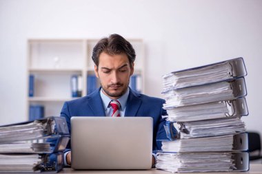 Genç işadamı ve ofiste çok fazla iş var.