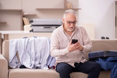Aged man preparing for trip at home