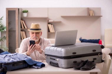 Aged man preparing for trip at home